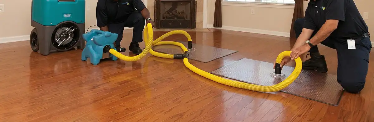 emergency water removal technicians extracting standing water from a home using professional equipment in Des Moines, IA